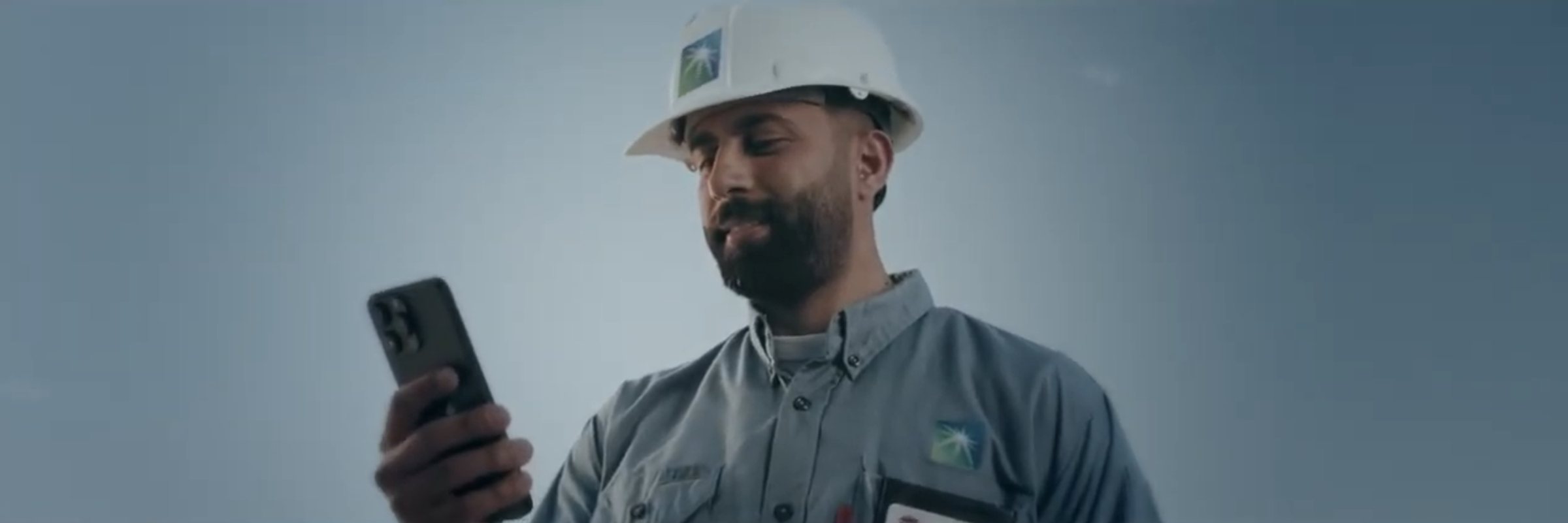 Aramco field worker looking at his phone